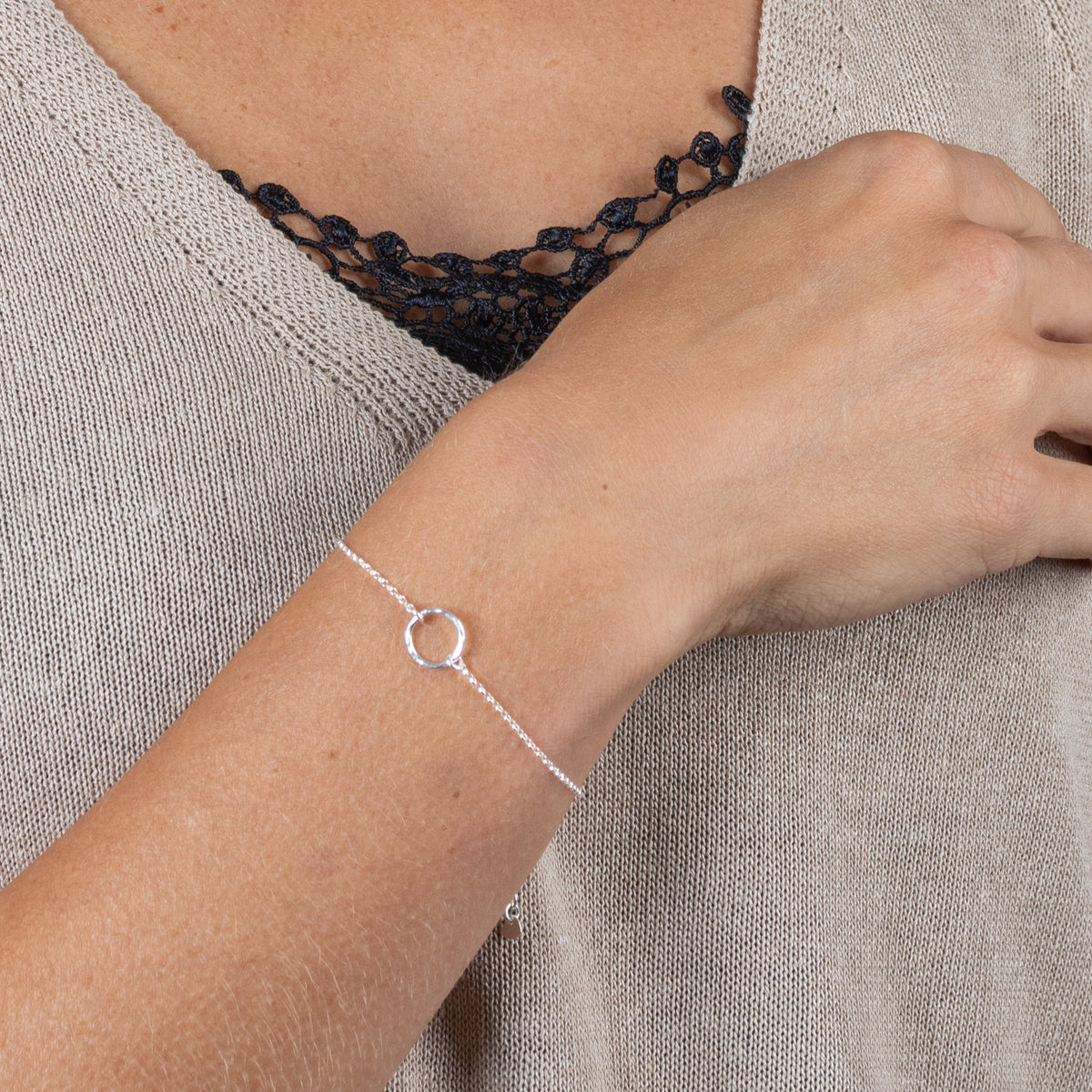 Filigranes Sterlingsilber Armband mit gehämmertem Ring in der Mitte, getragen am Handgelenk.