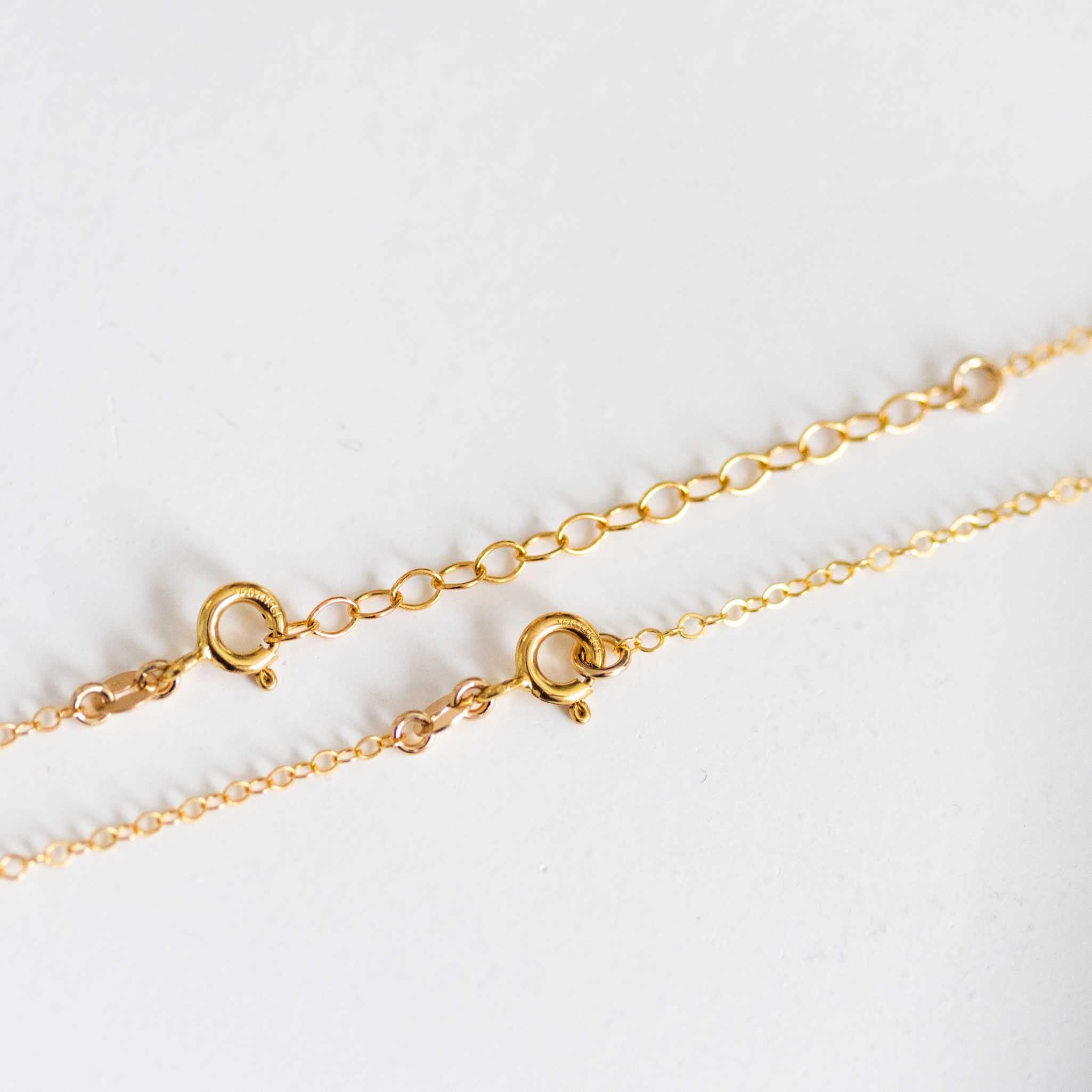Detailansicht des Verschlussbereichs einer feinen, goldenen Kette.