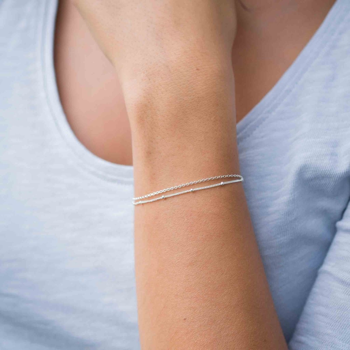 Am Handgelenk des Models hängt ein doppelreihiges Silber-Armband.