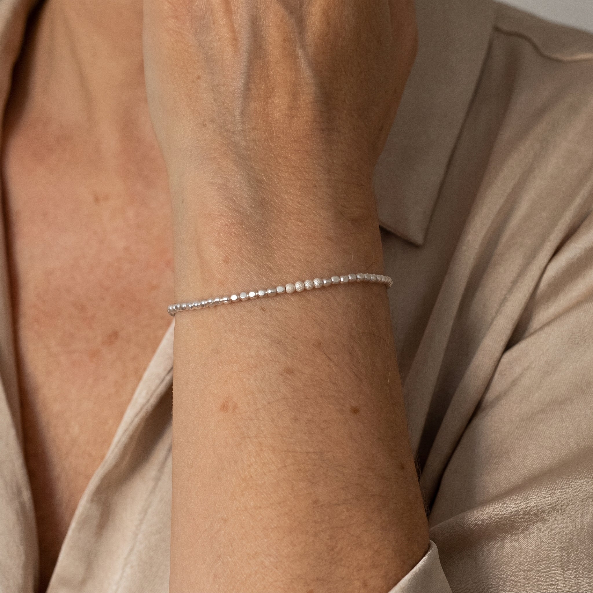 925 Silber Würfel-Armband mit gefrosteten Perlen in der Mitte am Handgelenk getragen.