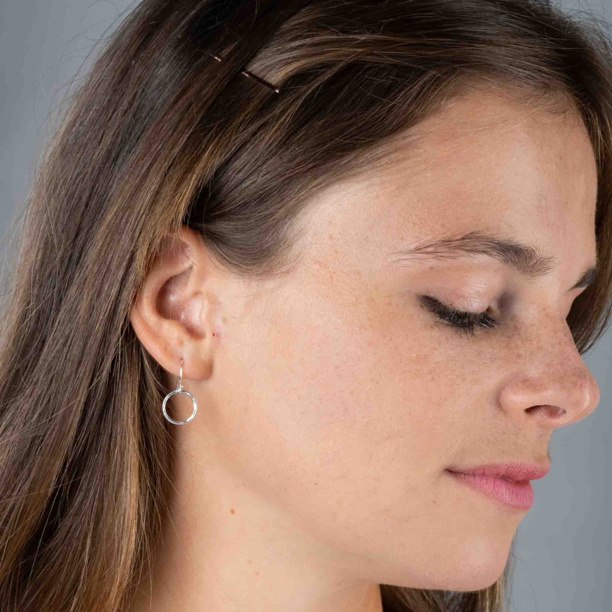 Am Ohr des Models hängt ein kleiner, gehämmerter Ohrring aus Sterling Silber.