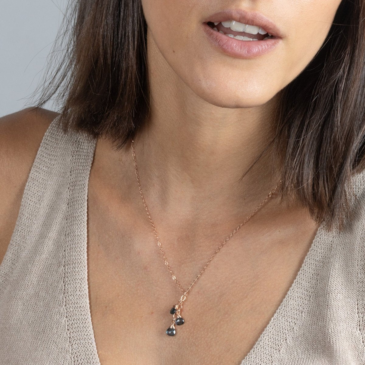 Am Hals des Models hängt eine feine Roségold-Kette mit drei kleinen, untereinander hängenden London Blautopas-Tropfen.