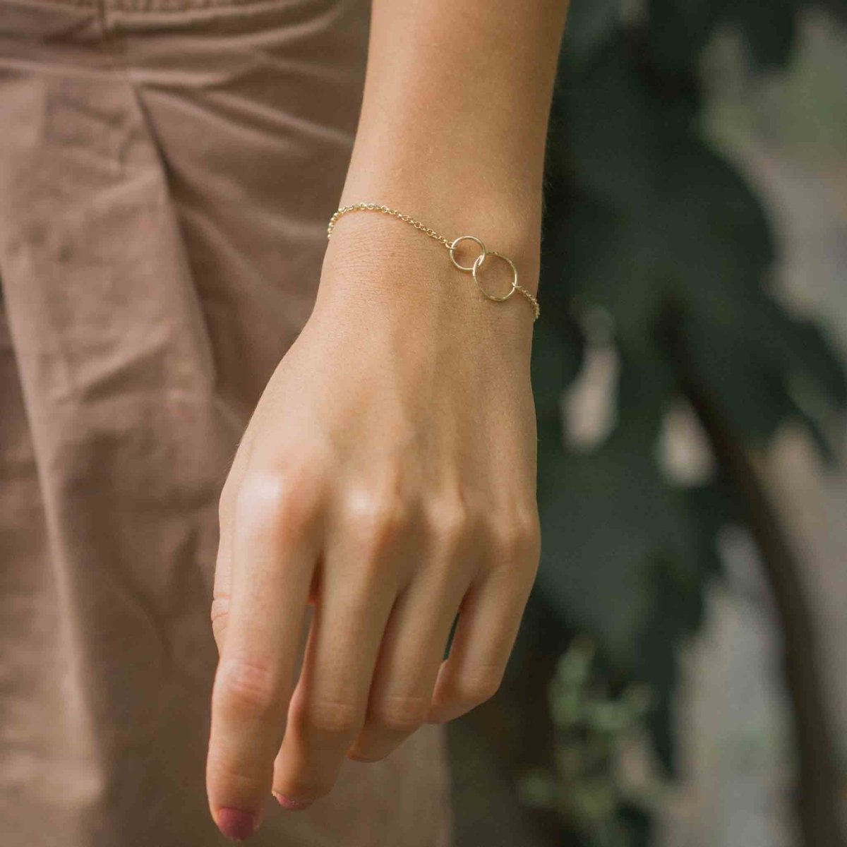 Vergoldetes 925 Silber-Armband mit zwei verschlungenen und gehämmerten Ringen am Handgelenk des Models.
