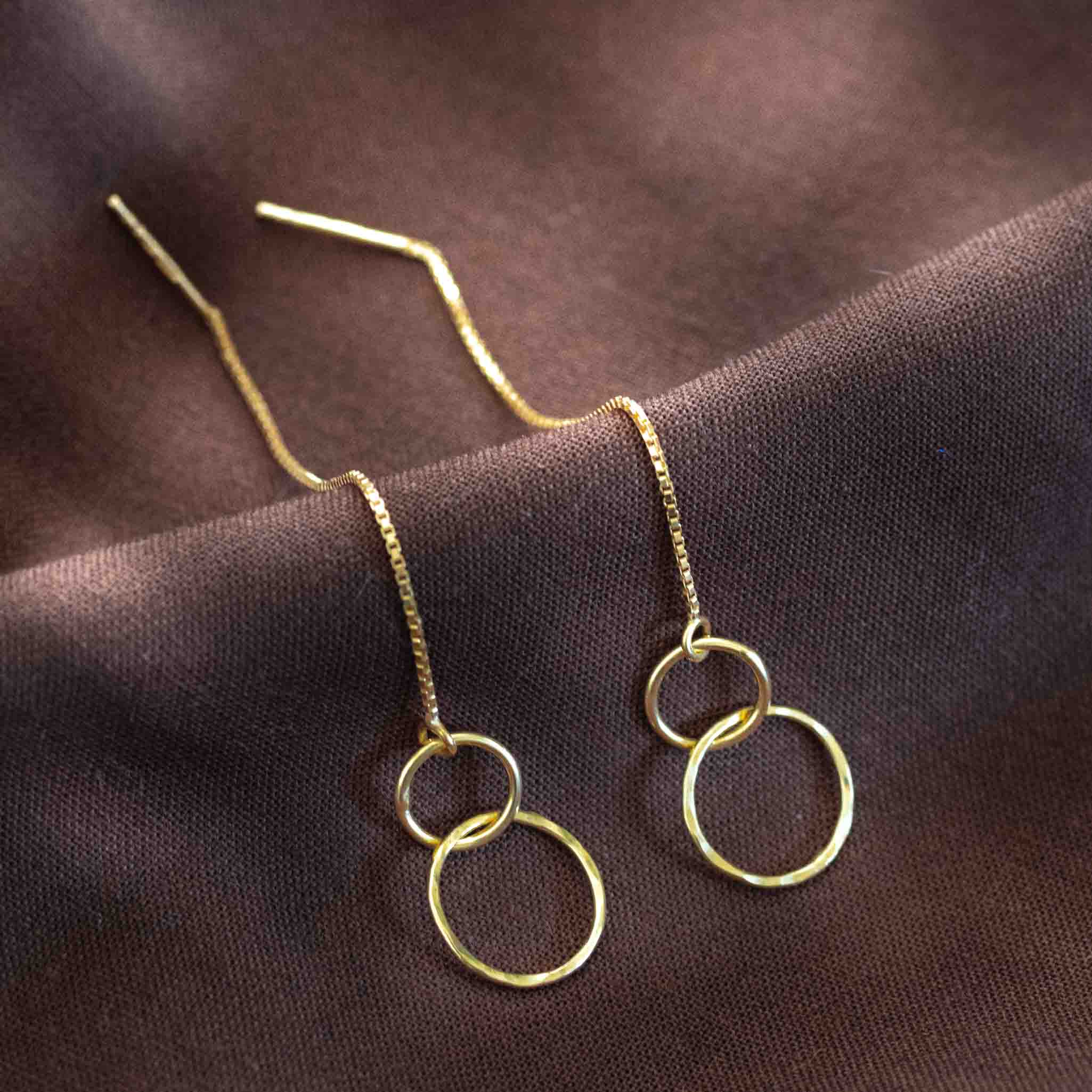 Goldene Einfädler Ohrringe mit gehämmerten Ringen.