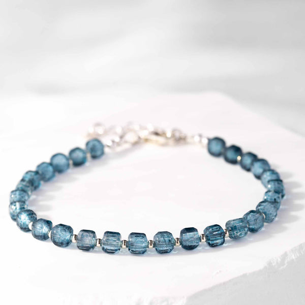 Ein blaues Topas Würfel Armband 925 Silber von Mayam Berlin liegt auf einer weißen Oberfläche.