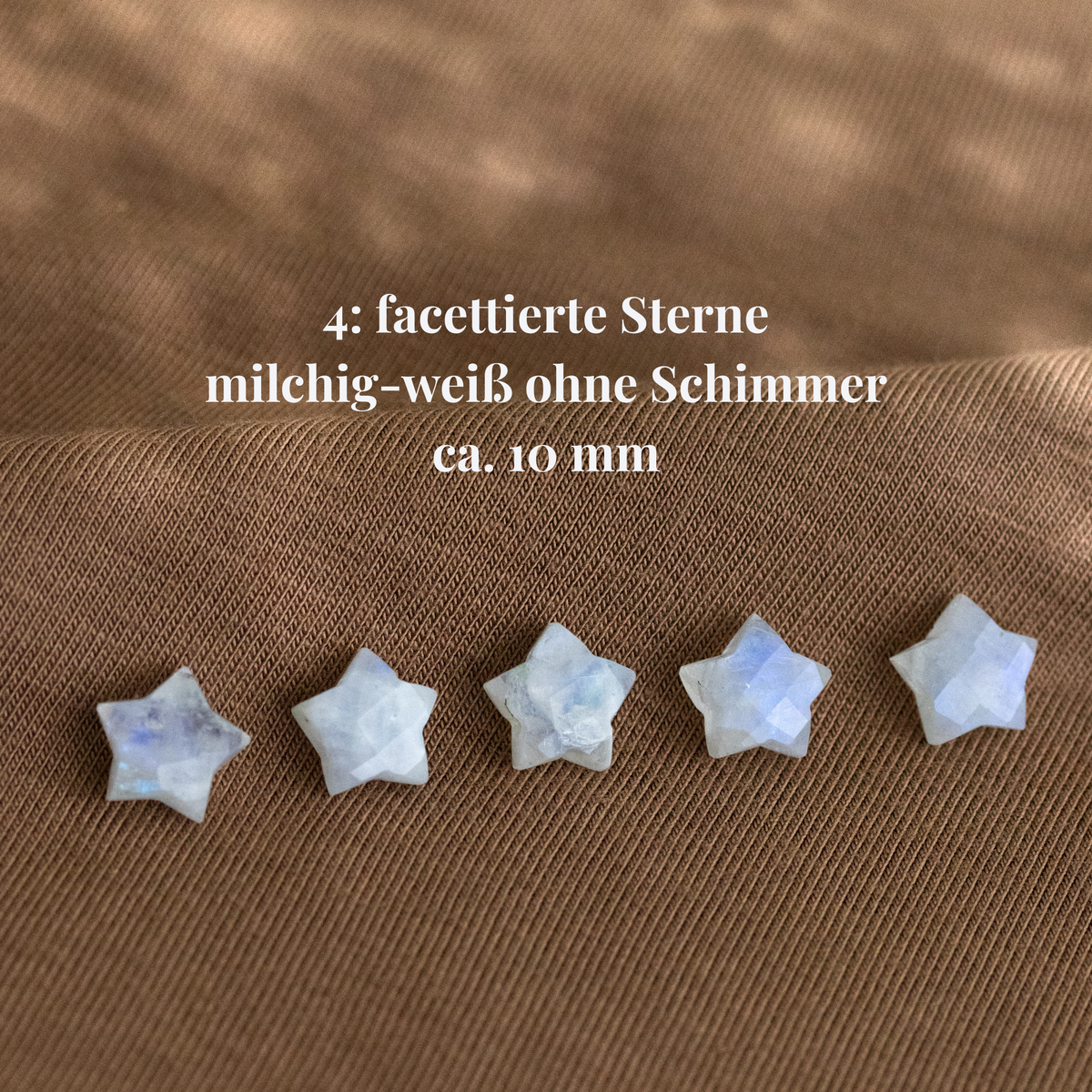Fünf sternenförmige Mondsteine auf Stoff ausgelegt. Beschriftung mit Hinweisen zu Maßen und Qualität.