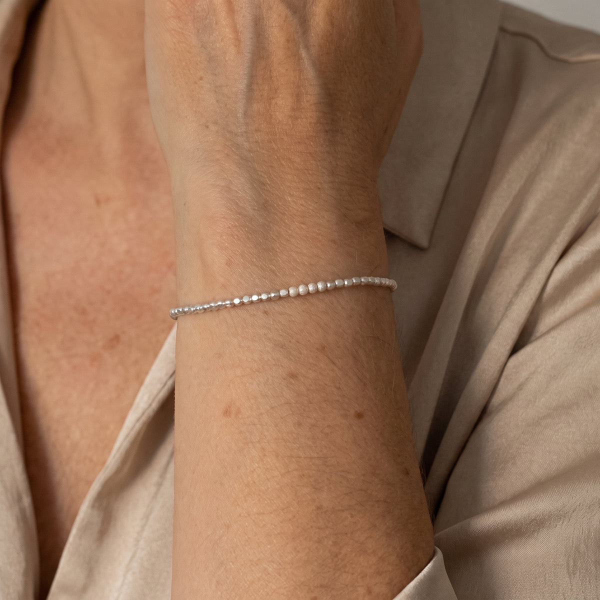 925 Silber Würfel-Armband mit gefrosteten Perlen in der Mitte am Handgelenk getragen.