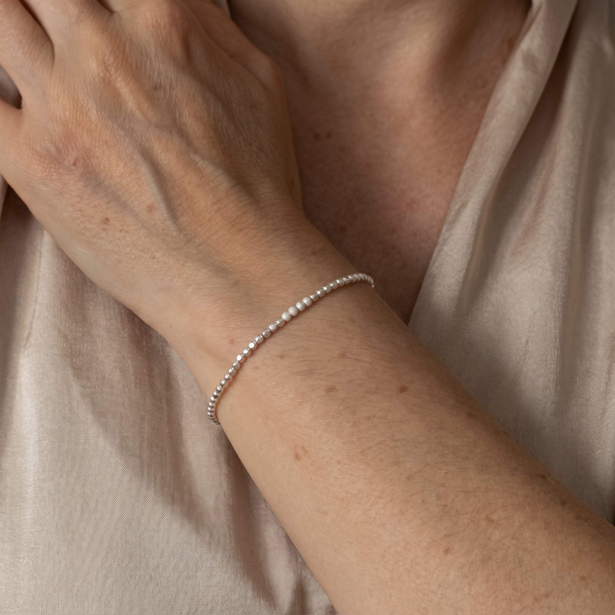 925 Silber Würfel-Armband mit gefrosteten Perlen in der Mitte am Handgelenk getragen.