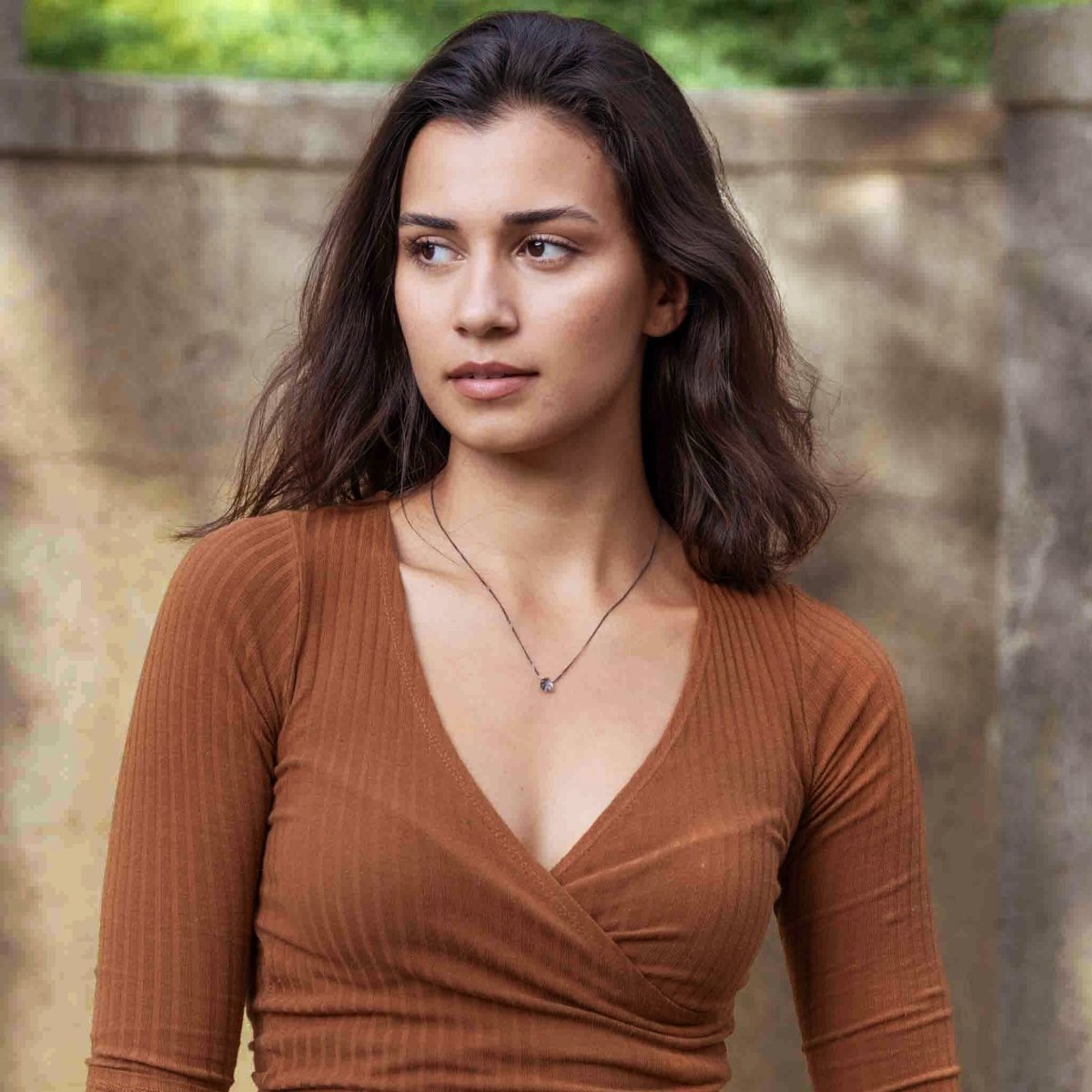 Am Hals des Models hängt eine dünne, geschwärzte Silberkette mit einem kleinen, tropfenförmigen Rutilquarz in der Mitte.