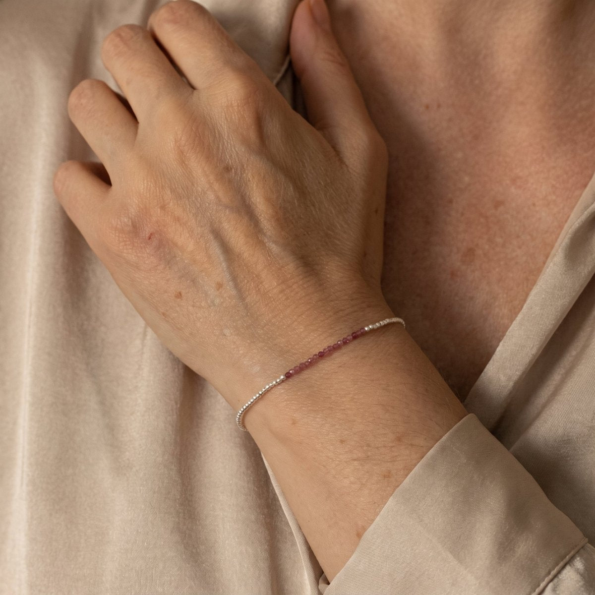 Am Handgelenk des Models hängt ein sehr dünnes Silberarmband mit einer Reihe rosa Turmaline.